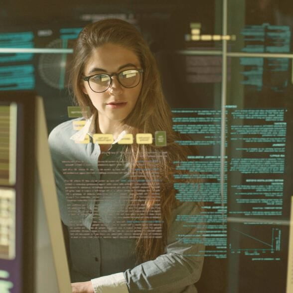 A woman doing 24/7 monitoring of several systems displayed on screens.